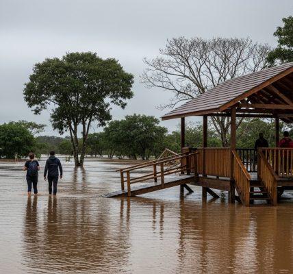 Campsite on higher ground beside a flooded river in Brazil, with tents pitched above water and protective gear visible.