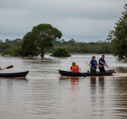 Flooded campsite in Brazil with rising water near tents and misty forest background.