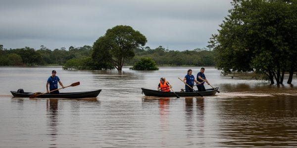 Flooded campsite in Brazil with rising water near tents and misty forest background.