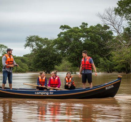 Flooded campsite in Brazil with rising water near tents and misty forest background.